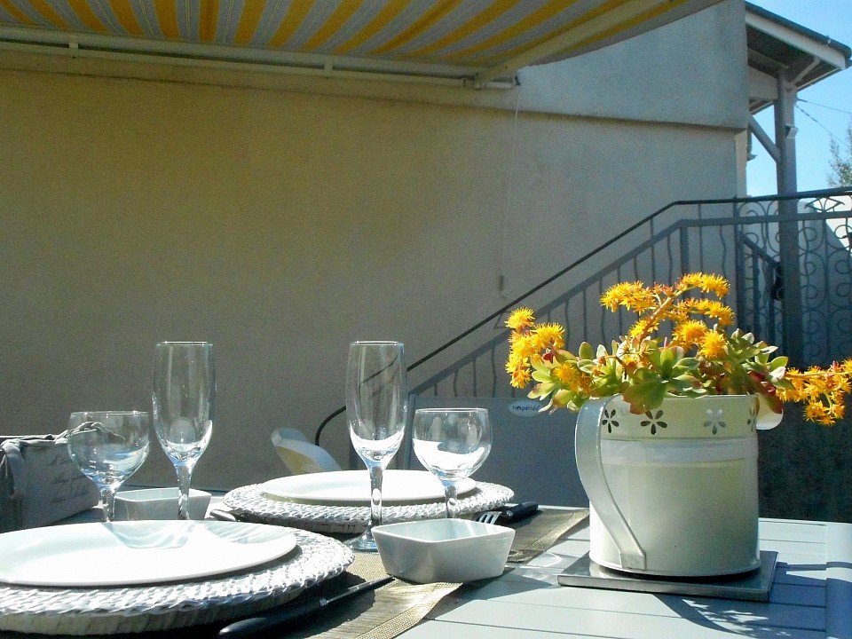 Table dressée sur la terrasse sans vis-à-vis ombragée par le store banne ©StudioNidCosyNérac